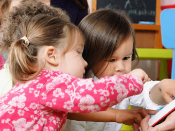 Small children reading a book together