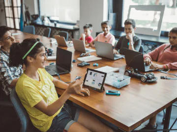 Children sitting around a desk with laptops