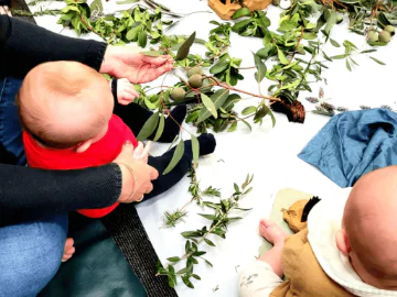 Parents holding their babies with they play with nature items