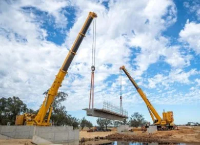 Cranes lifting concrete beams on a road construction in Swan