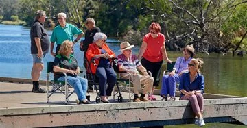 Elderly people sitting on a jetty on the Swan River