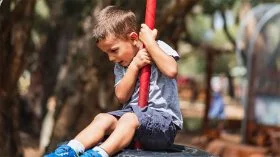 A child playing on a rubber tire swing