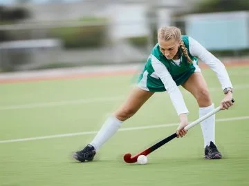 An action shot of a woman playing hockey