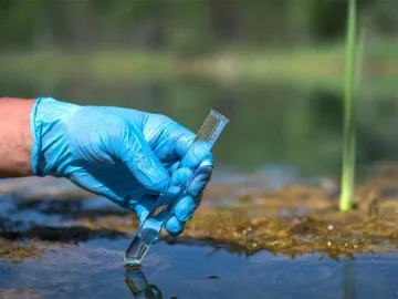 A water sample being taken using a test tube 