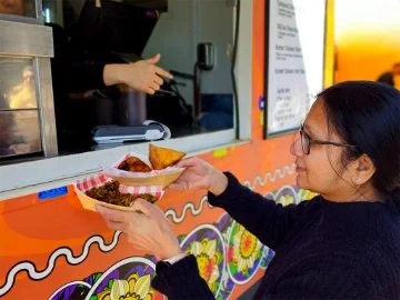 A customer picking up their food from a food van