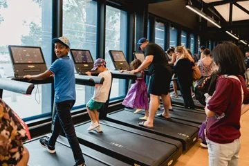 Children try out the treadmills in the gym.