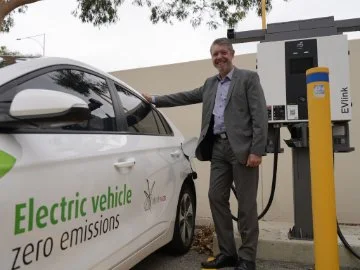 Stephen Cain, City of Swan CEO, with one of the City's electric vehicles plugged into a new charger.