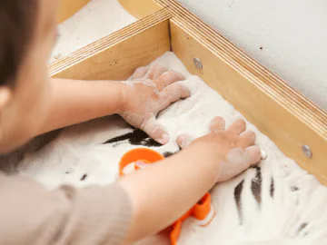 A child playing in a sensory tray