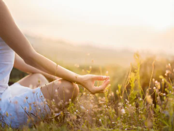 A person meditating in a field