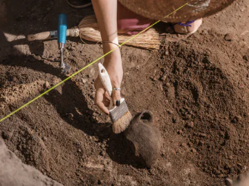 An archaeologist unearthing an artefact