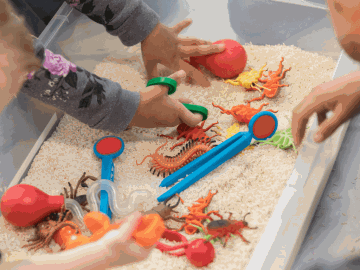 Children playing with plastic toys in sand